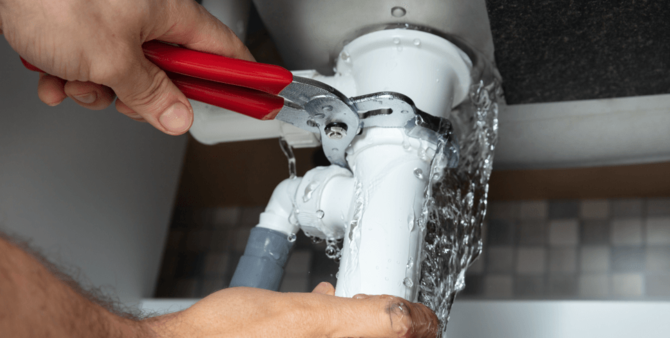 Person fixing leaky water in pipe