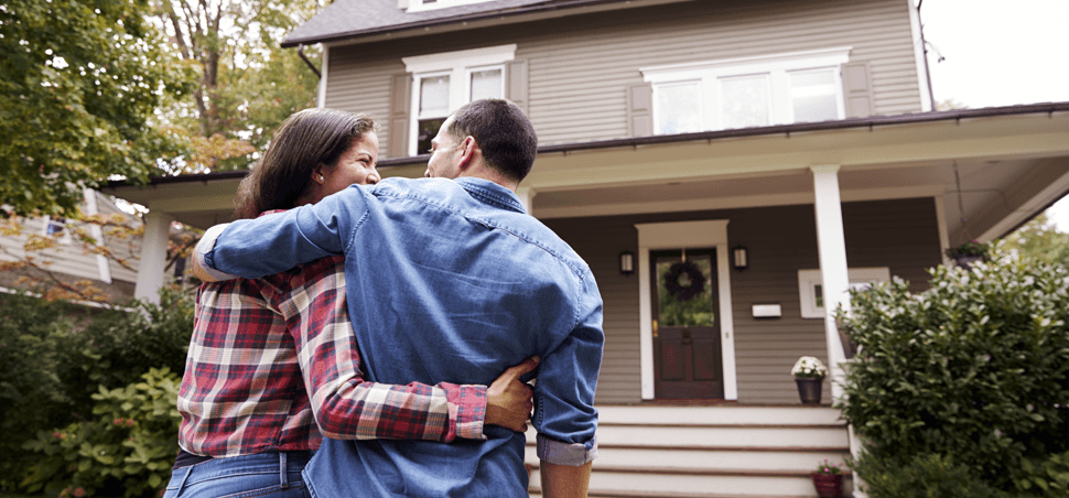 a couple embracing and walking to a house